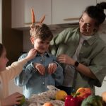 Mother and children have fun unpacking vegetables in the kitchen.