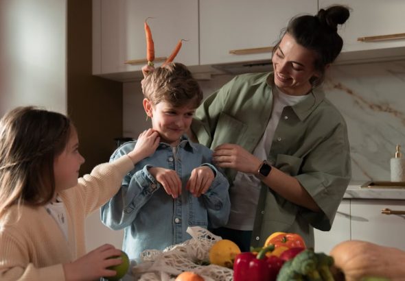 Mother and children have fun unpacking vegetables in the kitchen.