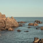 Serene view of rock formations emerging from the sea in Goseong-gun, South Korea, during the day.