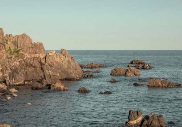 Serene view of rock formations emerging from the sea in Goseong-gun, South Korea, during the day.