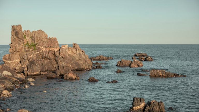 Serene view of rock formations emerging from the sea in Goseong-gun, South Korea, during the day.